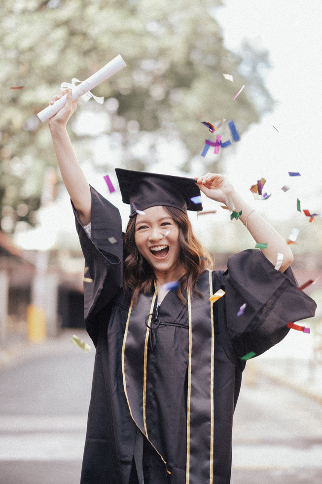 Successful College Graduate Raising Her Diploma